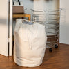 Removable canvas bag transforms hamper into portable laundry bag